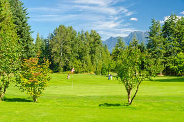 Fototapeta na wymiar Golf place with gorgeous green and fantastic mountain and blue sky view