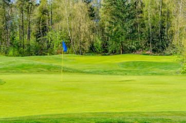 Obraz premium Golf course with gorgeous green and pond.