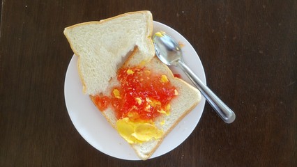  Breakfast. Bread, jam on a white plate. Can not eat all.