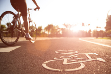 Close up cycling logo image on road with athletic women cyclist legs riding Mountain Bike in...