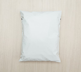 Blank white plastic bag package mockup template on wooden background.