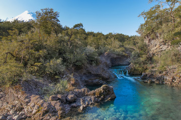 Caída de río en bosque con cielo azul