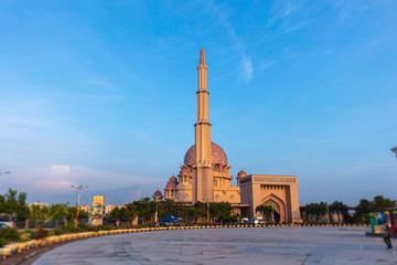 Obraz premium Putra Mosque or Masjid Putra, principal mosque of Putrajaya Wilaya, Malaysia, in the early morning for sunrise. In foreground the Malaysian flag with the state flags of all Malaysian states. 