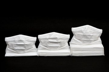 White surgical masks isolated on black background. Concept: statistics graph showing increased consumption of masks worldwide due to Coronavirus.