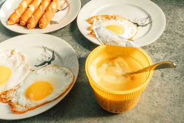 Homemade simple breakfast set of fried eggs and sausages in the morning.