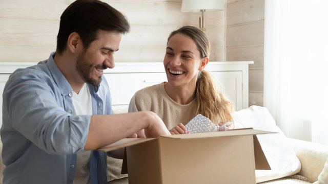 Happy young couple unpack box shopping online