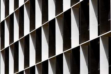 Black and white building facade under light and shadow.