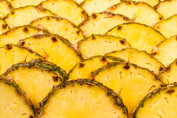 Pineapple juicy yellow slices background. Top view.