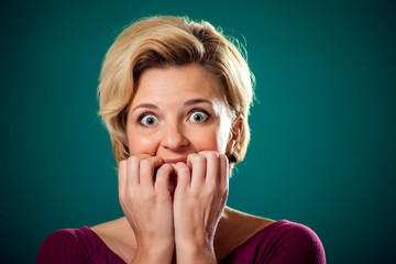 Scared woman in front of green background . People and emotions concept