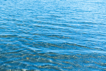 Obraz premium Sea blue water surface with waves near the shore. Background texture.