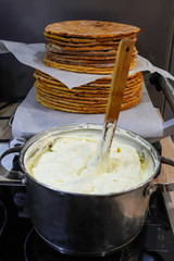 Baked cakes in front of which lies a pan with whipped cream. Ingredients for making a cake.