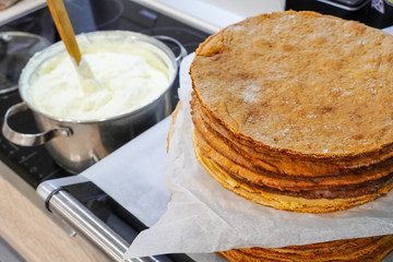 Making cake. Baked cakes of sweet dough on a background of whipped cream cream. Ingredients for making a cake.