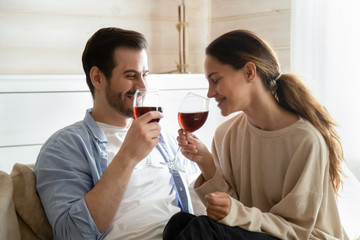Happy couple enjoy date drinking wine at home