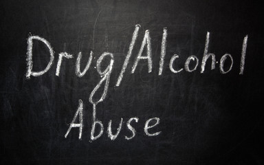 Fototapeta premium Drug alcohol abuse written in white chalk on a black chalkboard