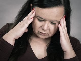 Worried woman having painfull headache