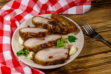 Baked pork belly in a plate on wooden table
