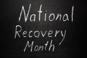 Fototapeta na wymiar National Recovery Month written in white chalk on a black chalkboard