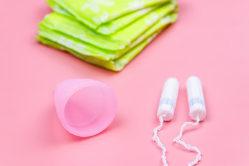 Fototapeta na wymiar Sanitary pad, tampons and menstrual cup on pink background. Concept of critical days, menstruation, feminine hygiene