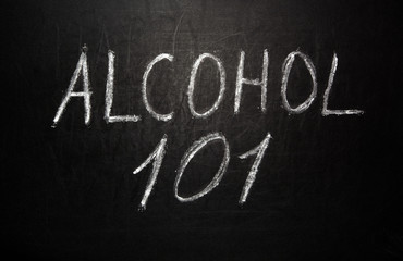 Fototapeta premium Alcohol 101 written in white chalk on a black chalkboard