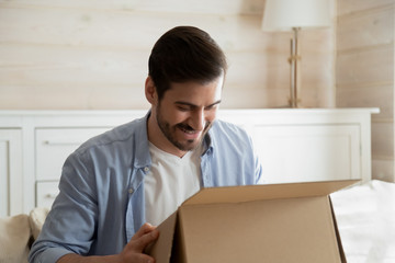 Overjoyed male customer unpack internet order package