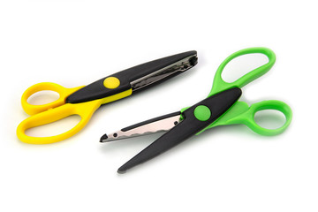 Two green and yellow zigzag craft scissors isolated on white background
