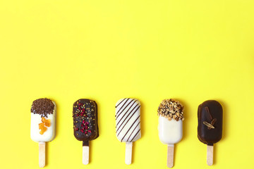 Chocolate popsicle. ice cream stick on yellow, lemon background, pastel color. Place for text, copy space