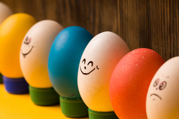 Eggs with funny faces on wooden  background