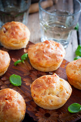 Muffins with ham and cheese on a wooden board, selective focus