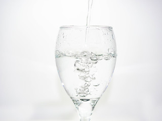 Pour water into the glass until small bubbles of various shapes are formed. White background