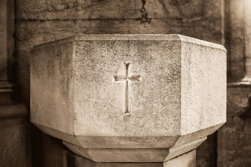 Close view of concrete holy water vessel with a cross