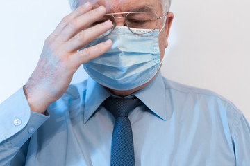 Coronavirus quarantine and Air pollution pm2.5 concept. Old sick man wearing respirator mask for protect holds hands near the face. Wuhan, China epidemic virus symptoms background.