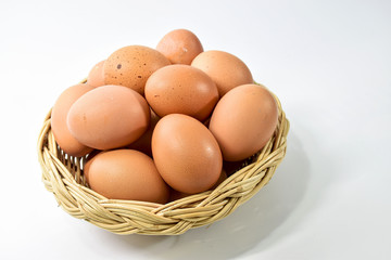 Eggs are laid in a wicker basket. On a white background