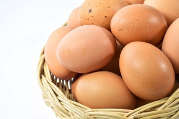 Eggs are laid in a wicker basket. On a white background