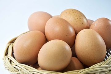 Eggs are laid in a wicker basket. On a white background
