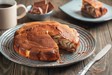 Homemade baking. Fragrant zebra cake with a crispy crust on a plate with coffee and chocolate