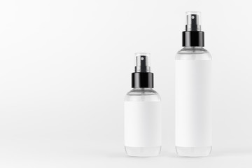 Tall, low transparent spray dispenser bottle for cosmetics with white label on white background, mock up for branding,  presentation, design.