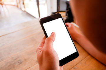 Mockup picture of business man’s hands holding smart phone with white blank screen in modern place.