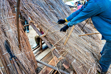 Demonstration of the rethatching old roof of a traditional Japanese house: binding process
