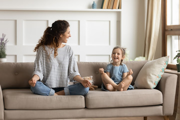 Fototapeta premium Happy mommy practicing yoga exercised with small child.