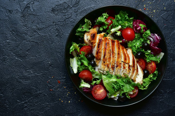 Fototapeta Grilled chicken fillet with vegetable salad. Top view with copy space. obraz