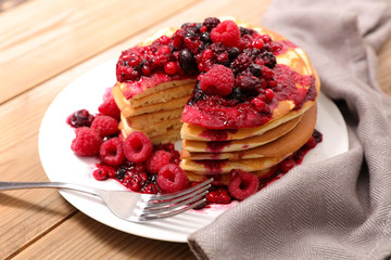 stack of pancakes with berry syrup
