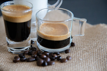 Espresso, milk and coffee beans on black background.