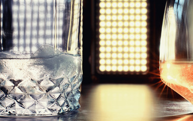 A glass of hard alcohol with ice on a bar counter. Whiskey with soda in a glass. Advertising alcoholic drink.