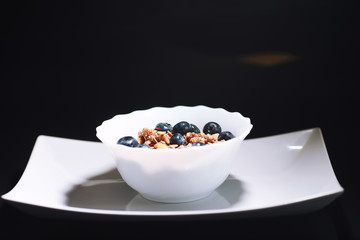 A healthy breakfast cereal with milk and fruit. Oat and corn flakes with chocolate and yogurt. The concept of healthy and vegetarian food.
