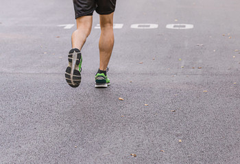 A man and a  woman are jogging in the evening on the public park