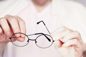 The concept of poor vision. Hold a contact lens and glasses in hand. A poster for advertising...