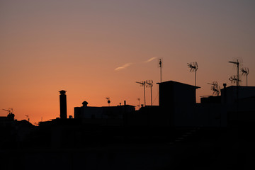 Fototapeta na wymiar Silhouette of houses and antennas in the neighbourhood Gracia in Barcelona Spain at Sunrise