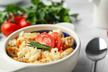 Delicious chicken risotto served in bowl, closeup