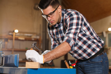 Professional carpenter working with wooden plank in workshop