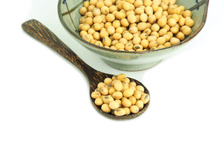 Soybeans in wooden spoon with bowl isolated on white background. 